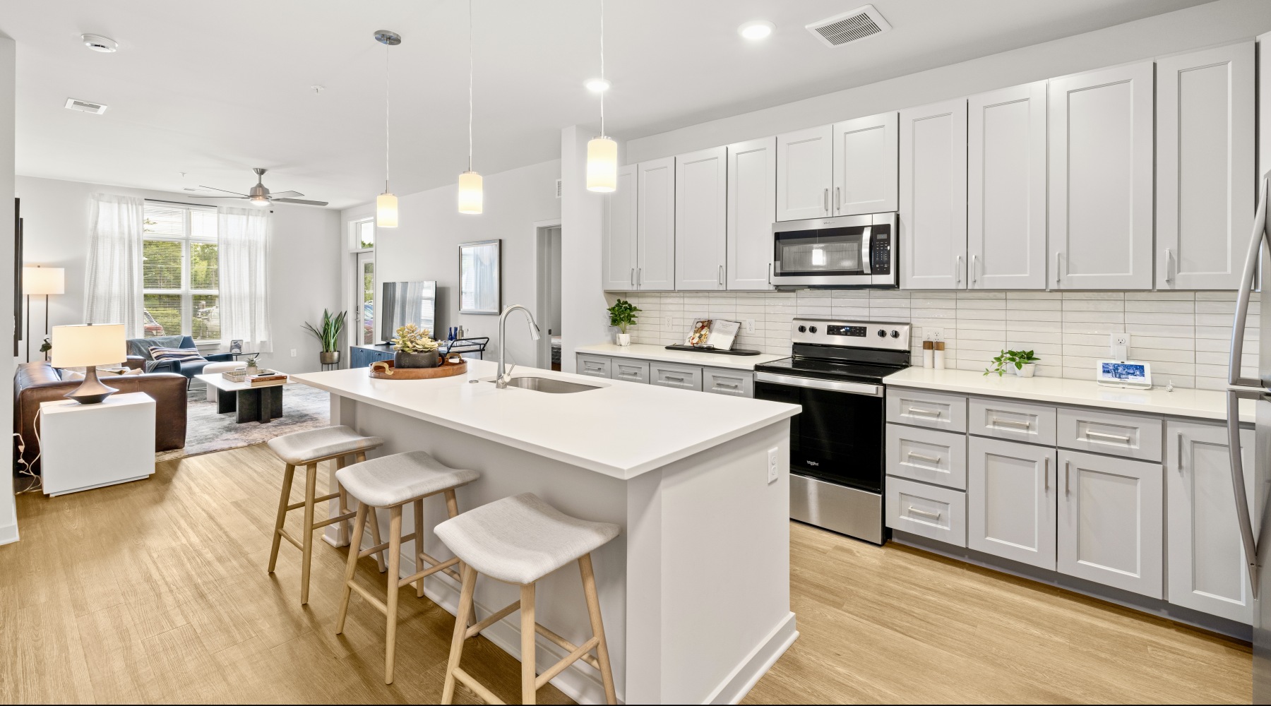 pendant lights over kitchen island facing a living room