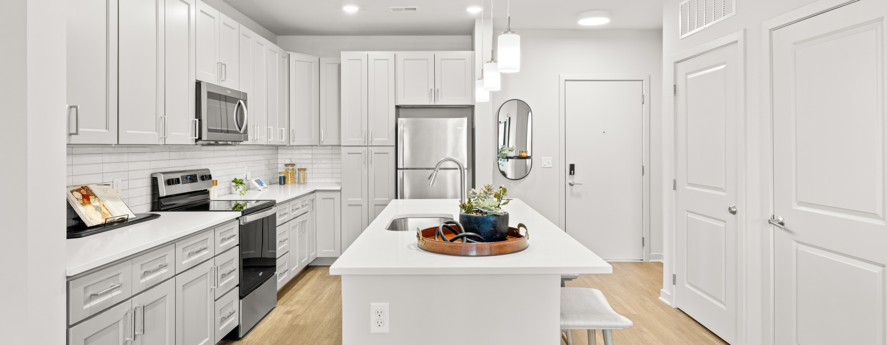 A bright kitchen with gray cabinets and an island